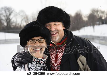 Stock Photograph - Portrait of Caucasian middle aged man and woman wearing black winter hats smiling at viewer.. Fotosearch