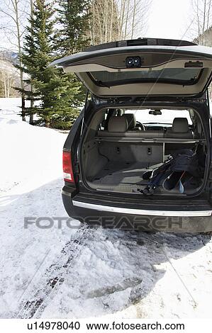 Stock Image - SUV with ski equipment in winter setting.. Fotosearch