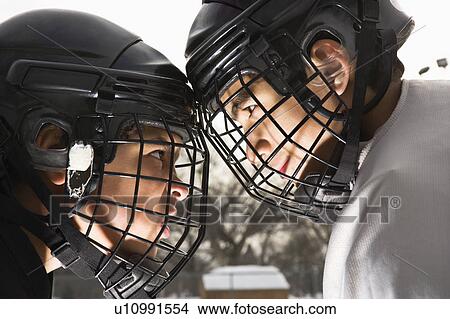 Picture - Two ice hockey players in uniform facing off trying to intimidate each other.. Fotosearch