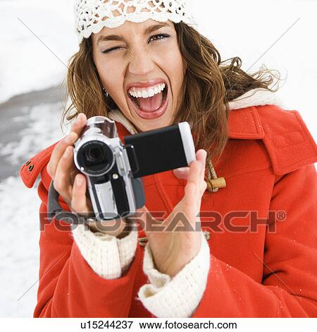 Young adult female in winter clothing pointing digital camera at viewer and winking View Large Photo Image Stock Photo - Young adult female in winter clothing pointing digital camera at viewer and winking. Fotosearch