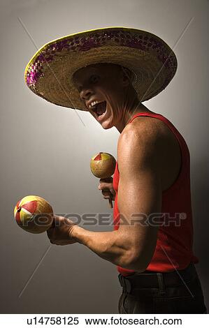 Stock Photography - Male wearing sombrero holding maracas. Fotosearch