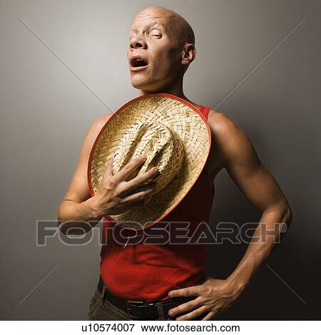 Portrait of a Mid-adult Caucasian male holding stray hat over chest. View Large Photo Image Stock Photo - Portrait of a Mid-adult Caucasian male holding stray hat over chest.. Fotosearch