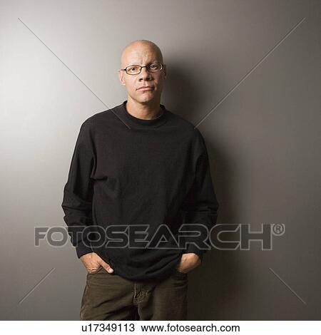 Stock Image - Portrait of mid-adult Caucasian male with hands in pockets.. Fotosearch