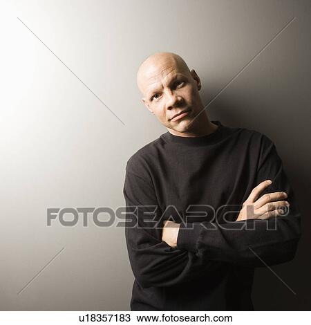 Stock Image - Portrait of mid-adult Caucasian male with arms crossed.. Fotosearch