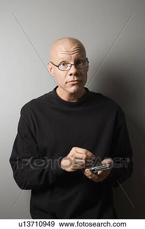 Portrait of mid-adult Caucasian male holding PDA. View Large Photo Image Stock Photo - Portrait of mid-adult Caucasian male holding PDA.. Fotosearch