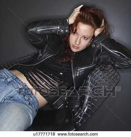 Stock Photo - Portrait of pretty redhead young woman holding hands to head.. Fotosearch