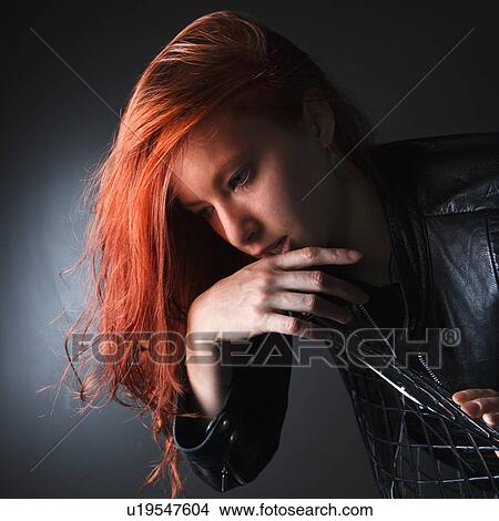 Pretty redhead young woman wearing leather jacket hanging over back of chair View Large Photo Image Picture - Pretty redhead young woman wearing leather jacket hanging over back of chair. Fotosearch