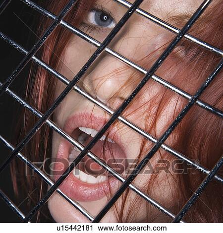 Woman with mouth open behind metal fence. View Large Photo Image Stock Image - Woman with mouth open behind metal fence.. Fotosearch