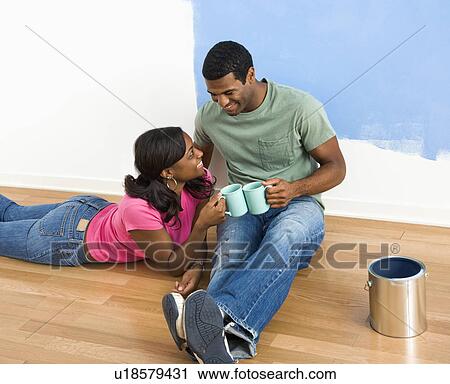 African American couple relaxing together with coffee next to half-painted wall. View Large Photo Image Stock Image - African American couple relaxing together with coffee next to half-painted wall.. Fotosearch