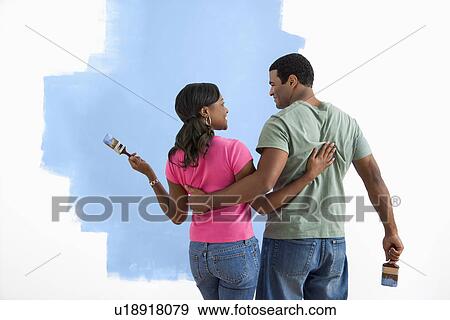 African American couple standing together looking at half-painted wall. View Large Photo Image Stock Photo - African American couple standing together looking at half-painted wall.. Fotosearch
