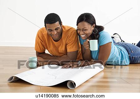 African American male and female couple lying on floor looking at architectural blueprints. View Large Photo Image Stock Photography - African American male and female couple lying on floor looking at architectural blueprints.. Fotosearch
