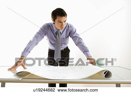 Business man standing looking over blueprints View Large Photo Image Stock Image - Business man standing looking over blueprints. Fotosearch