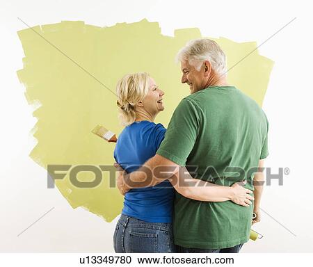 Couple painting wall green observing and discussing their work View Large Photo Image Stock Image - Couple painting wall green observing and discussing their work. Fotosearch