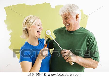 Stock Photo - Couple playing with paint utensils.. Fotosearch