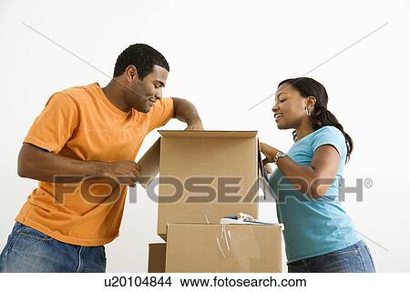 Male and female couple packing cardboard boxes View Large Photo Image Picture - Male and female couple packing cardboard boxes. Fotosearch