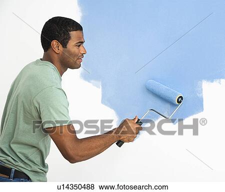 Stock Photo - Man painting wall blue. Fotosearch