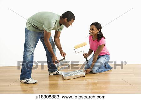 Smiling man pouring paint into tray as female looks on View Large Photo Image Stock Image - Smiling man pouring paint into tray as female looks on. Fotosearch
