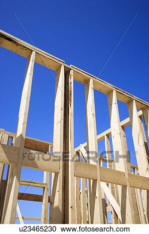 Wooden framework of new construction with blue sky in background. View Large Photo Image Stock Image - Wooden framework of new construction with blue sky in background.. Fotosearch