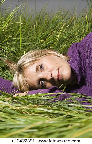 Middle-aged Caucasian woman lying in grass. View Large Photo Image Stock Image - Middle-aged Caucasian woman lying in grass.. Fotosearch