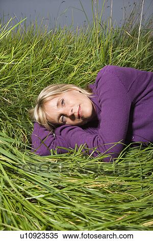 Middle-aged Caucasian woman lying on side in grass. View Large Photo Image Stock Photography - Middle-aged Caucasian woman lying on side in grass.. Fotosearch