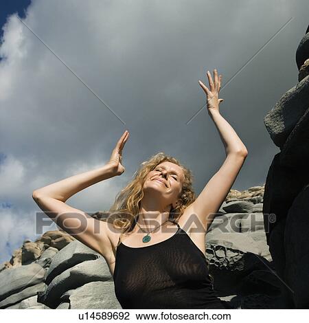 Woman with arms raised in air in rocky terrain View Large Photo Image Stock Image - Woman with arms raised in air in rocky terrain. Fotosearch