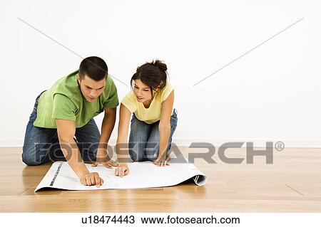 Attractive young adult couple looking at house plans. View Large Photo Image Stock Image - Attractive young adult couple looking at house plans.. Fotosearch