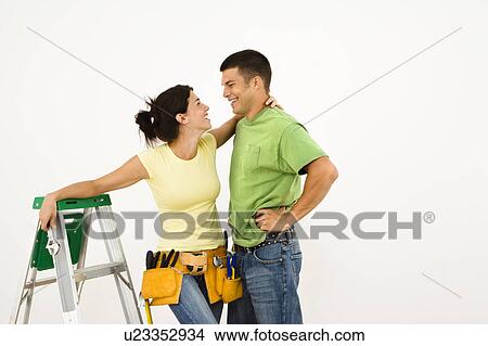 Couple with tools and ladder standing in home smiling View Large Photo Image Picture - Couple with tools and ladder standing in home smiling. Fotosearch