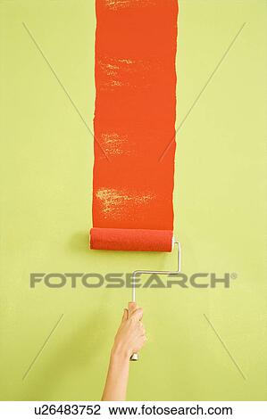 Stock Image - Hand painting red stripe on green wall. Fotosearch