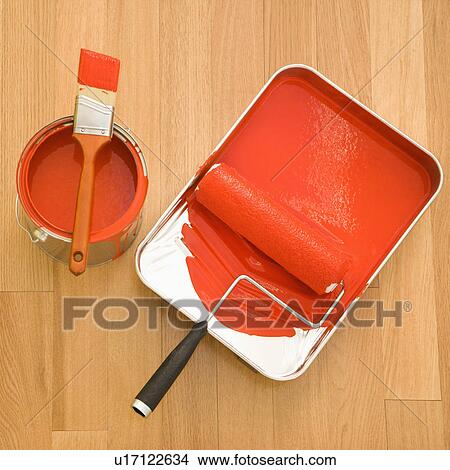 High angle of paint roller in tray with paint can on wood floor. View Large Photo Image Picture - High angle of paint roller in tray with paint can on wood floor.. Fotosearch