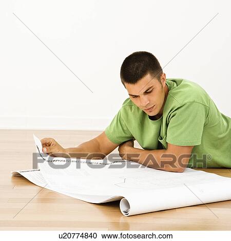 Man lying on floor in home reading house plans View Large Photo Image Stock Image - Man lying on floor in home reading house plans. Fotosearch