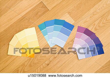 Stock Photo - Paint color swatches grouped together by color on wood floor. Fotosearch