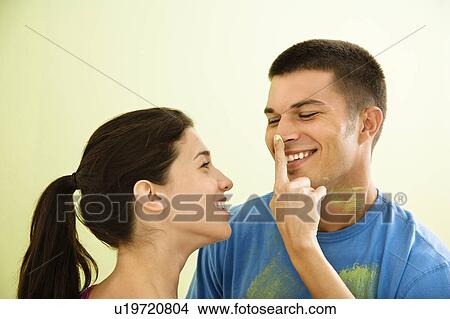 Playful smiling woman putting paint on man's nose. View Large Photo Image Picture - Playful smiling woman putting paint on man's nose.. Fotosearch