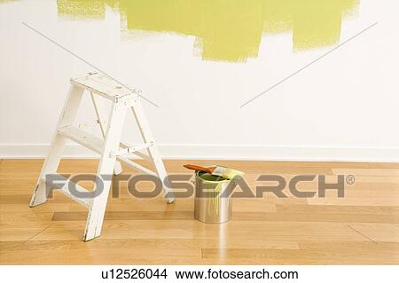 Picture - Still life of paintbrush on paint can with stepladder painted wall.. Fotosearch