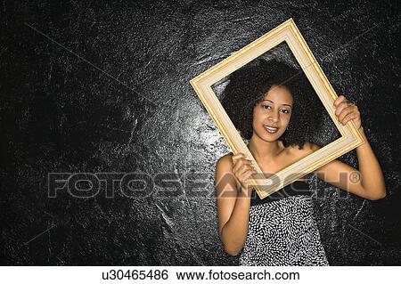 African-American woman holding frame over her face. View Large Photo Image Stock Photograph - African-American woman holding frame over her face.. Fotosearch