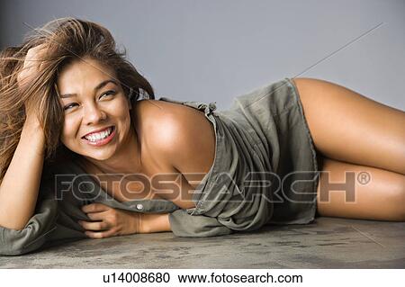 Attractive Asian female lying on ground with happy expression. View Large Photo Image Stock Image - Attractive Asian female lying on ground with happy expression. . Fotosearch