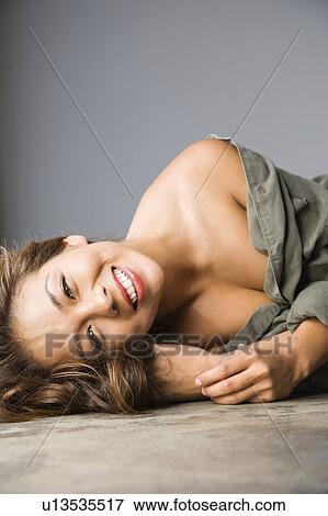 Attractive Asian female lying on ground with happy expression. View Large Photo Image Stock Photo - Attractive Asian female lying on ground with happy expression. . Fotosearch