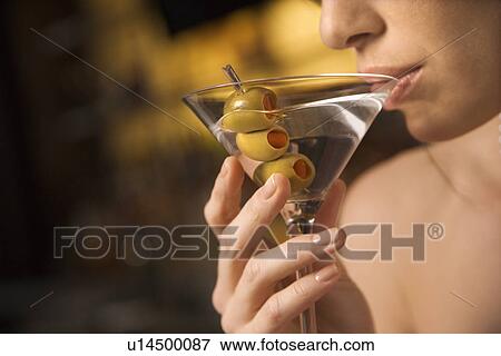 Close up of mid adult Caucasian woman drinking a martini with three olives. View Large Photo Image Stock Photo - Close up of mid adult Caucasian woman drinking a martini with three olives.. Fotosearch