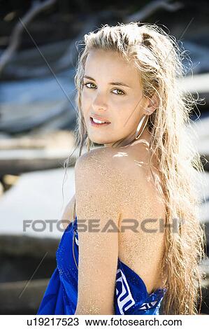 Stock Image - Half length portrait of bare young Caucasian woman on Maui, Hawaii beach.. Fotosearch