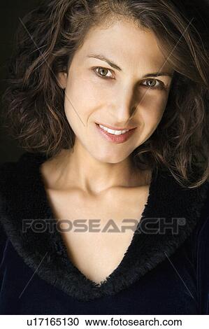 Stock Image - Head and shoulder portrait of pretty brunette woman smiling.. Fotosearch