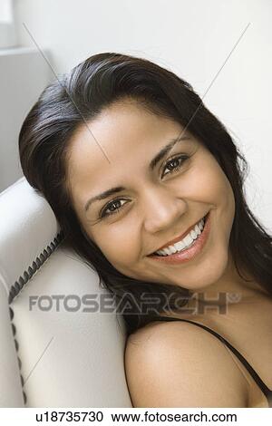 Stock Image - Head shot of smiling Hispanic woman looking at viewer. . Fotosearch