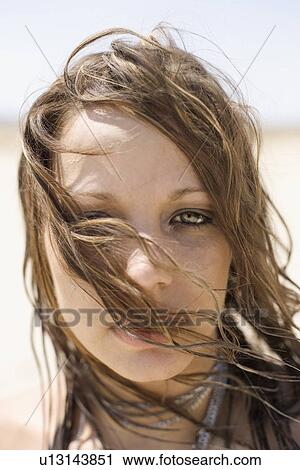 Portrait of Caucasian mid-adult woman with hair blowing across face looking at viewer. View Large Photo Image Stock Image - Portrait of Caucasian mid-adult woman with hair blowing across face looking at viewer.. Fotosearch