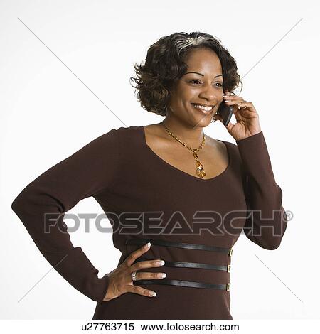 Stock Photography - Portrait of woman holding telephone to ear and smiling.. Fotosearch