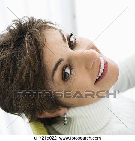 Stock Image - Portrait of woman smiling over her shoulder. Fotosearch