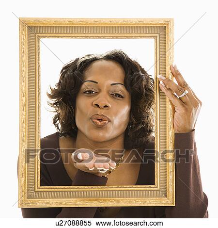 Woman holding frame around head blowing out kiss. View Large Photo Image Stock Photography - Woman holding frame around head blowing out kiss.. Fotosearch