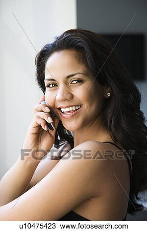 Young adult woman looking at viewer and talking on cell phone View Large Photo Image Stock Image - Young adult woman looking at viewer and talking on cell phone. Fotosearch