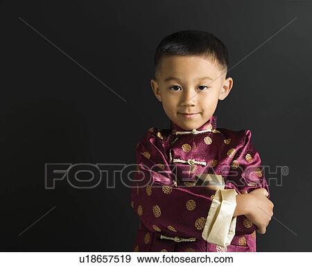 Asian boy in traditional attire standing against black background. View Large Photo Image Stock Photo - Asian boy in traditional attire standing against black background.. Fotosearch