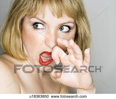Stock Image - blonde woman who is looking off to the side with a disgusted expression. Fotosearch