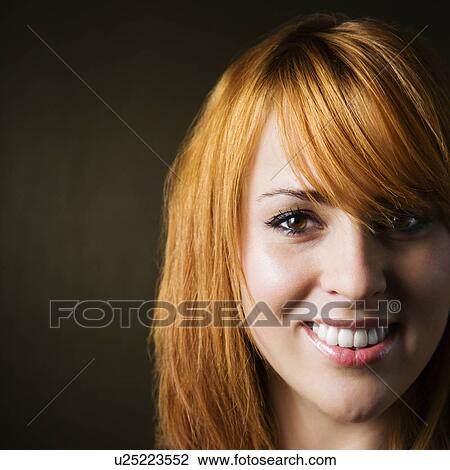 Stock Image - Close-up studio portrait of pretty young redheaded female. Fotosearch