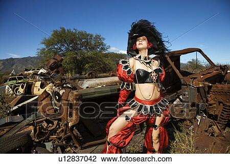 Stock Image - Female dressed in pirate costume in junkyard. Fotosearch