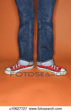 Stock Photo - Jeans and sneakers with feet turned outward. Fotosearch